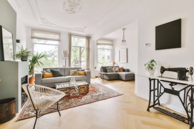 Çağdaş dairenin pencerelerine karşı rahat kanepesi ve televizyonu olan oturma odası.