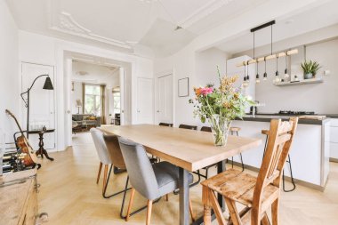 Minimalist tarzı açık mutfağı ve masa ve sandalyeleri olan geniş yemek alanı olan modern çatı katı dairesinin ev tasarımı.