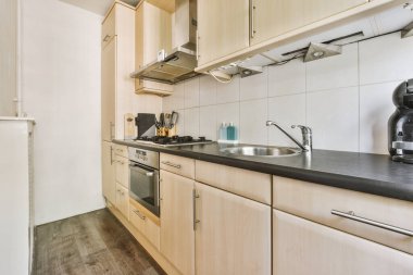 Minimalist tarzı beyaz mobilyalı, lavabolu ve sobalı bir ev mutfağı.