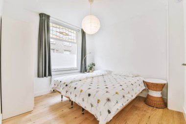 Yatak odasının iç tasarımı, yatak odası ve ahşap gardırop modern dairenin penceresinin kenarına yerleştirilmiş.