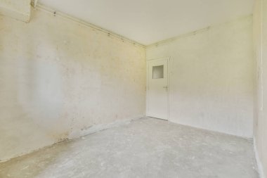 Evdeki boş ışık odasında, beyaz duvardaki plastik pencere ve radyatör.