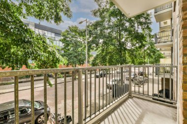 Panoramic view of buildings with trees from small balcony