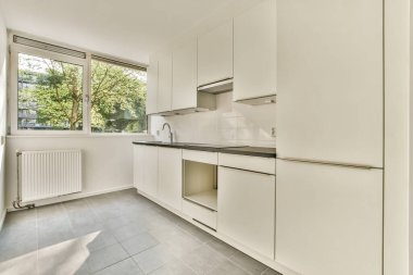 Interior of empty white kitchen with windows