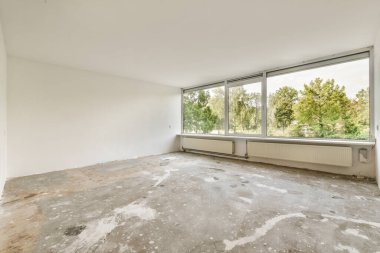 Evdeki boş ışık odasında, beyaz duvardaki plastik pencere ve radyatör.