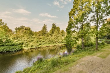 Front view of river and trees from small balcony with glass partition