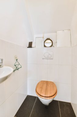 Lavabolu ve duvarlı, beyaz duvarlı ve kareli tuvaletli dar bir tuvalet.