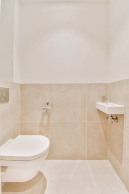 Lavabolu ve duvarlı, beyaz duvarlı ve kareli tuvaletli dar bir tuvalet.