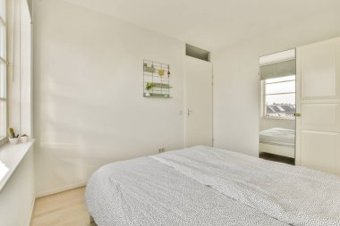 Comfortable bed and cupboard located in in contemporary bedroom at home