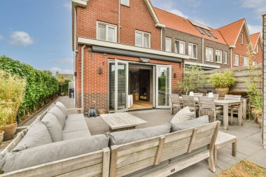 Neat powerful patio with sitting area and small garden near wooden fence