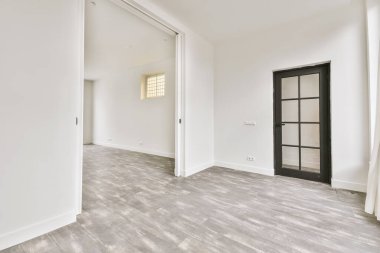 Evdeki boş ışık odasında, beyaz duvardaki plastik pencere ve radyatör.