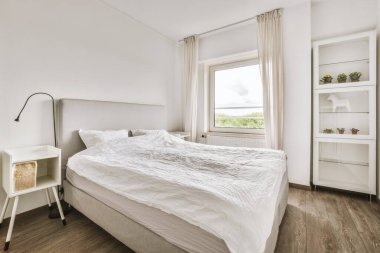 Yatak odasının iç tasarımı, yatak odası ve ahşap gardırop modern dairenin penceresinin kenarına yerleştirilmiş.