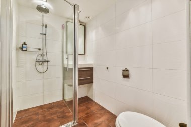 Çağdaş apartmandaki açık tuvaletteki cam kapılı ve aynalı döşeme.