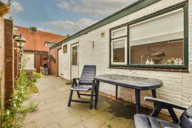 Neat powerful patio with sitting area and small garden near wooden fence