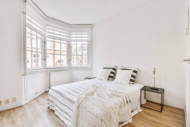 Yatak odasının iç tasarımı, yatak odası ve ahşap gardırop modern dairenin penceresinin kenarına yerleştirilmiş.