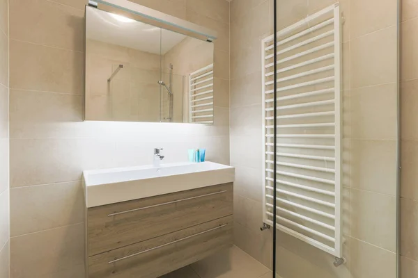 Interior of contemporary bathroom with shabby beige walls and partitions.