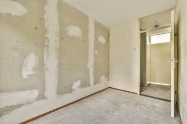 Evdeki boş ışık odasında, beyaz duvardaki plastik pencere ve radyatör.