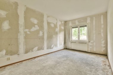 Evdeki boş ışık odasında, beyaz duvardaki plastik pencere ve radyatör.