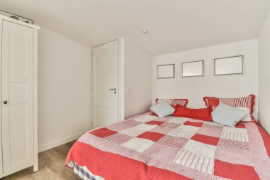 Comfortable bed with blanket and pillows in small bedroom