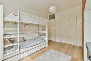 Interior of modern kid bedroom with bunk bed and shelves with various toys at home