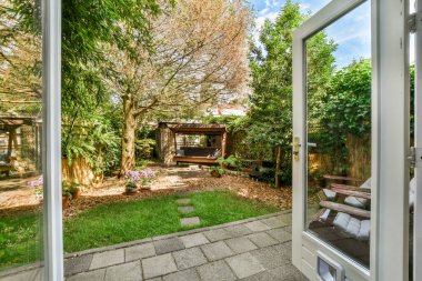 Neat powerful patio with sitting area and small garden near wooden fence