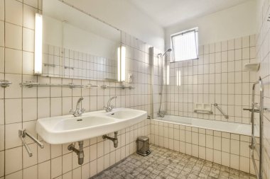 Bathroom with white tiled walls near sink in light