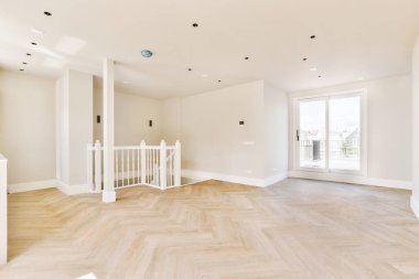 Büyük balkon pencereli, perdeli ve ahşap parke zeminli boş beyaz odanın içi.