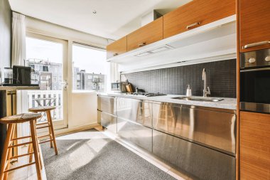 Günümüz minimalist tasarımı. Hafif stüdyo dairesinin ahşap masası ve oturma odası ile beyaz duvarları ve parke zemini arasında yemek masası ve sandalyeleri var.