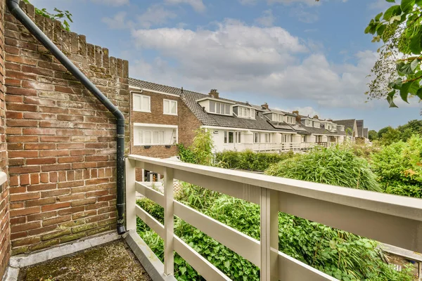 Panoramic view of buildings with trees from small balcony