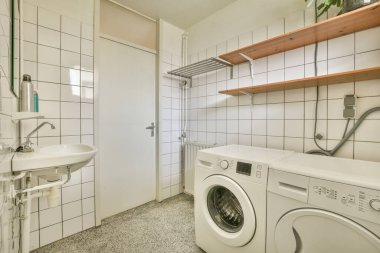 Hortumlu ve çamaşır makineli duş odasının içi.