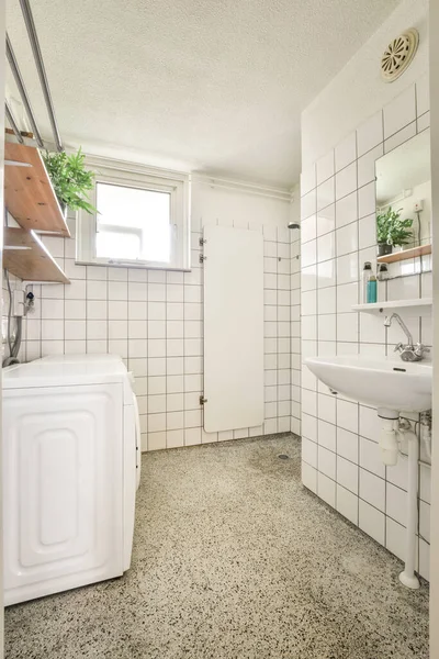 Interior of shower room with hose and washing machine