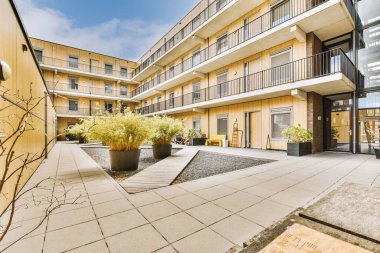 Ağaçlar ve fenerlerle dolu boş bir kaldırım sokağından tuğla evler manzarası