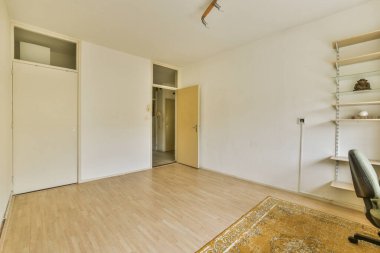 Battaniyeli rahat yatak ve yastıklar küçük yatak odasındaki pencereye dayanan lambayla dolap ve komodinin yanında.