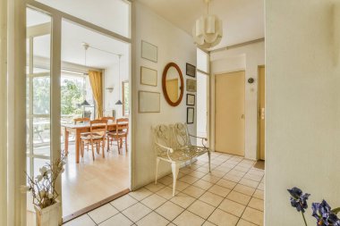 Modern evdeki hafif yemek odasına açılan kapısı ve penceresi olan şık bir koridor.