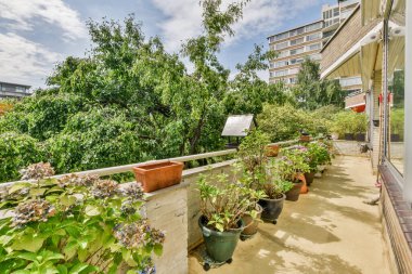 Pencerenin yanında küçük bahçesi olan basit küçük bir balkon.