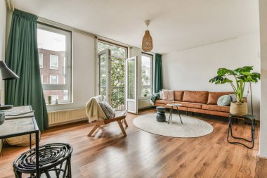 Yastıkları olan rahat bir kanepe. Duvara yaslanmış TV ve dekorasyonlar modern sevgi odasında.