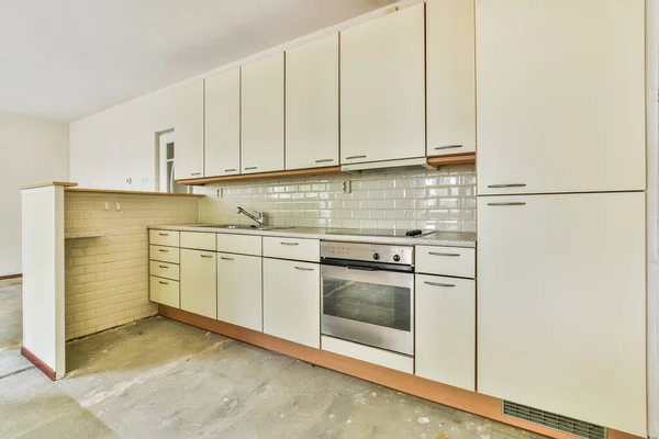 Interior of empty room with open kitchen and large balcony windows