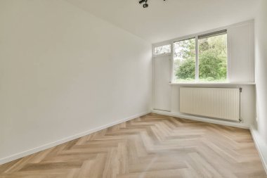 Evdeki boş ışık odasında, beyaz duvardaki plastik pencere ve radyatör.