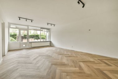 Evdeki boş ışık odasında, beyaz duvardaki plastik pencere ve radyatör.