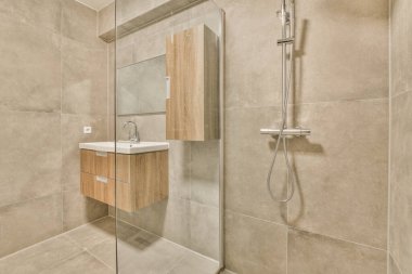 Evdeki modern tuvalette banyo musluğu ile banyo arasında cam bölme.
