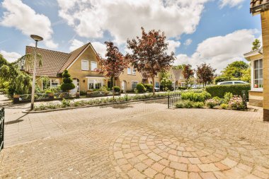 Arabaları, ağaçları ve fenerleri olan boş bir kaldırımdan panorama manzaralı evler.