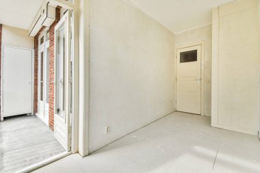 Evdeki boş ışık odasında, beyaz duvardaki plastik pencere ve radyatör.