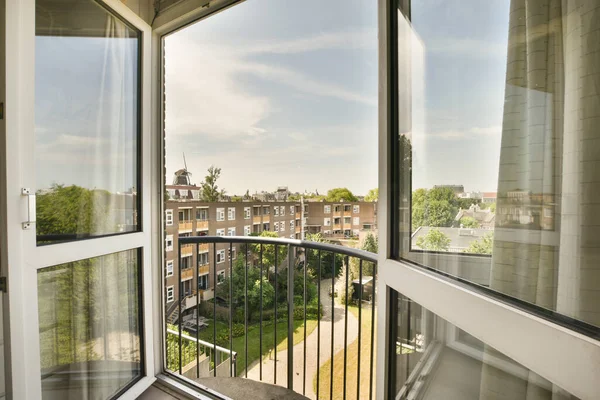 Panoramic view of brick buildings with and trees from small balcony