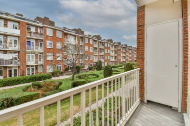 Eski tuğlalı binaların ve bisikletli arabaların ön manzarası küçük balkondan tırabzanlara kadar uzanıyor.