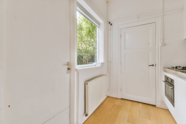 Minimalist tarzı beyaz mobilyalı, lavabolu ve sobalı bir ev mutfağı.