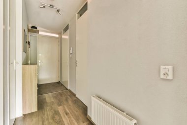 Işık dar koridor, beyaz duvarlarda birçok kapı ve kereste zemininde parlayan lamba