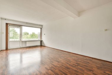 Evdeki boş ışık odasında, beyaz duvardaki plastik pencere ve radyatör.