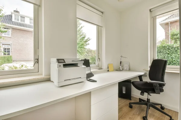 現代のフラットの光の家のオフィスで窓のあるテーブルの近くに配置快適な椅子 — ストック写真