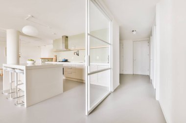 Günümüz minimalist tasarımı. Hafif stüdyo dairesinin ahşap masası ve oturma odası ile beyaz duvarları ve parke zemini arasında yemek masası ve sandalyeleri var.