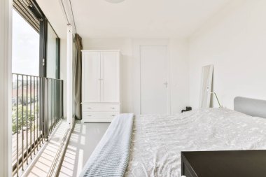 Yatak odasının iç tasarımı, yatak odası ve ahşap gardırop modern dairenin penceresinin kenarına yerleştirilmiş.