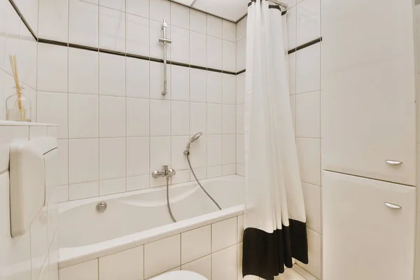 在带有白色瓷砖墙壁的现代浴室里 用镜子和干净的浴缸洗澡 — 图库照片